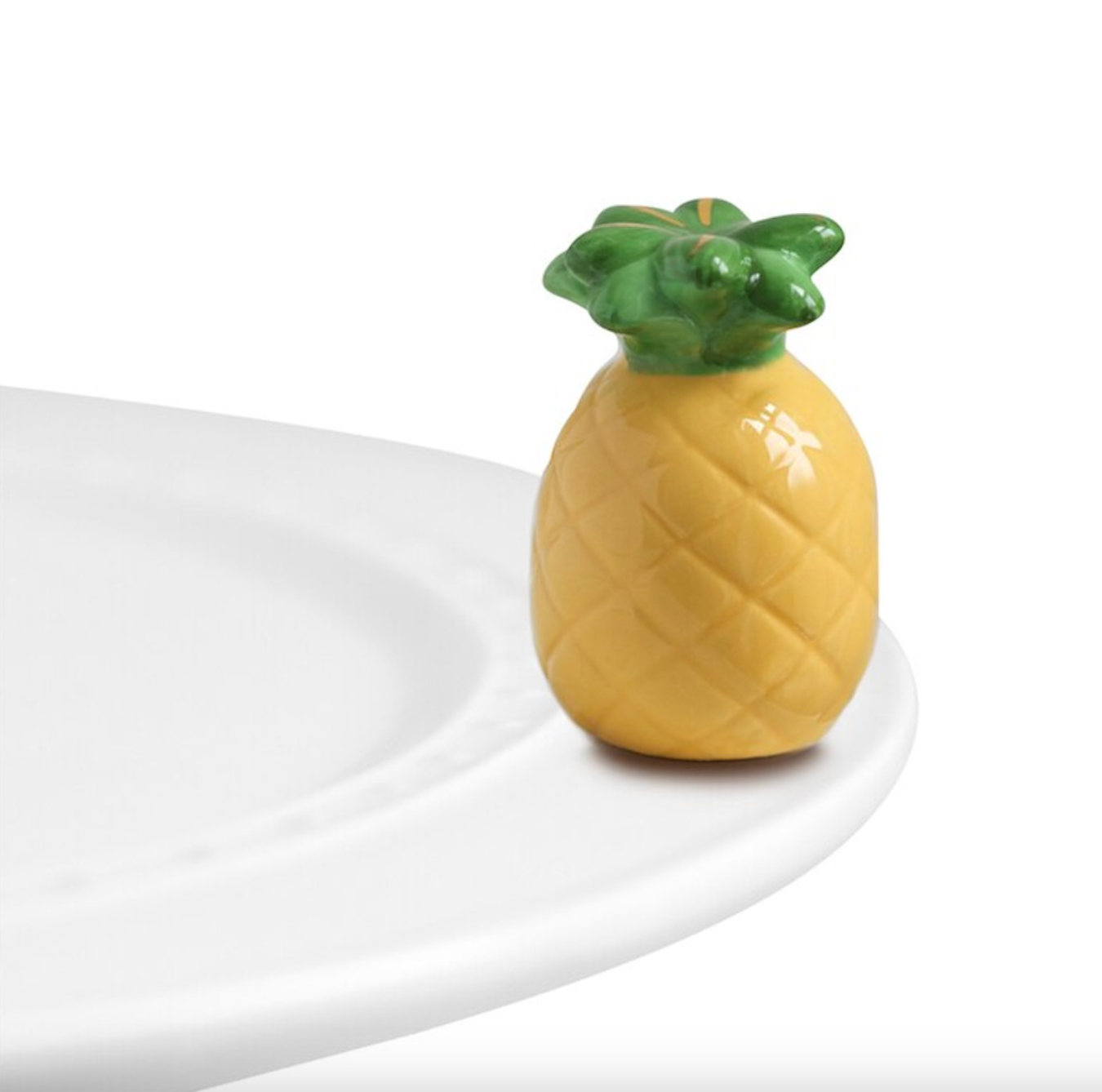 A miniature pineapple-shaped dish charm placed on a white plate against a white background. Available at Be Charmed