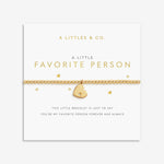 Gold bracelet with heart charm on a white card from A Littles & Co. 