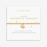 Gold bracelet with heart charm on a white card from A Littles & Co. 