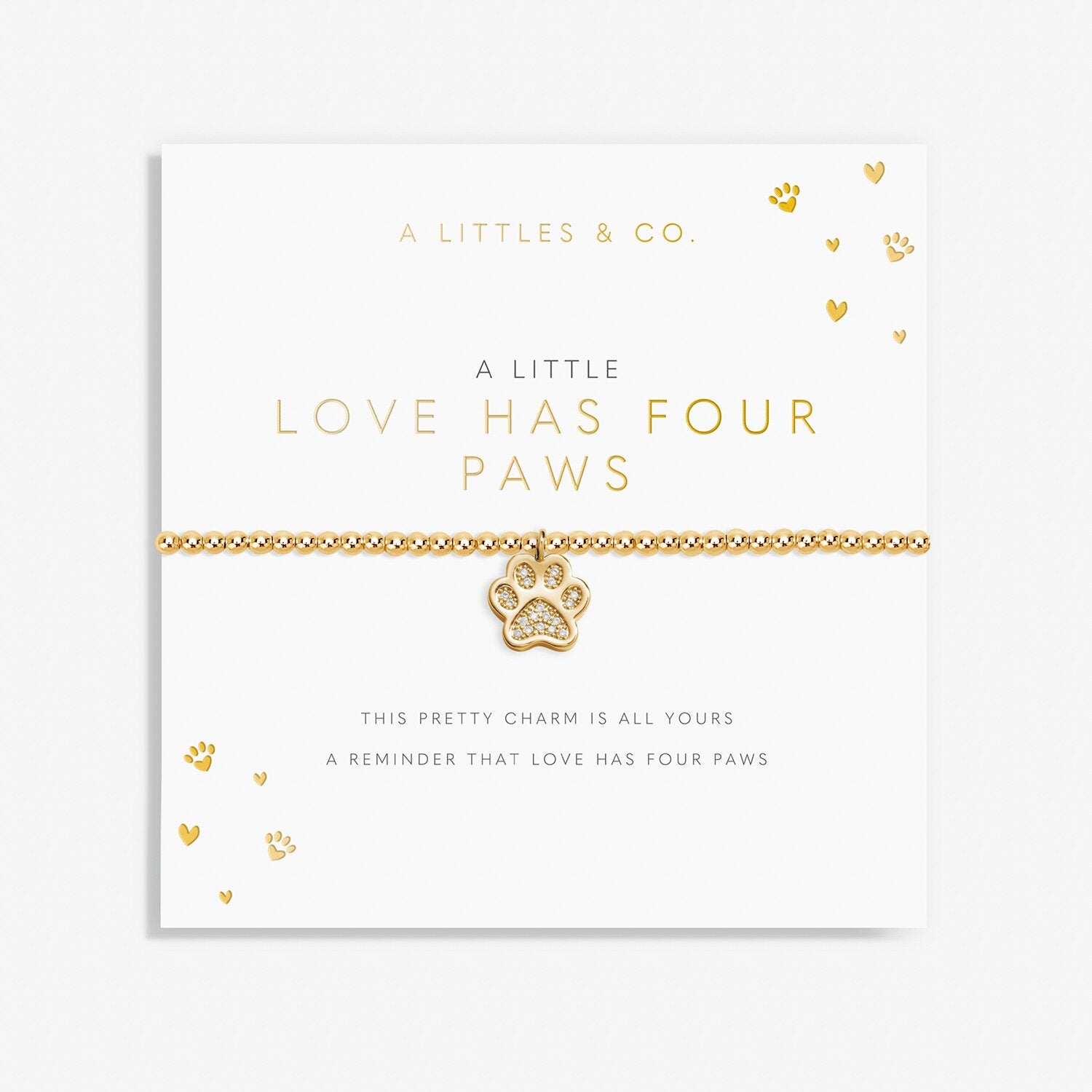 Gold bracelet with paw charm on a white card with text. Available at Be Charmed