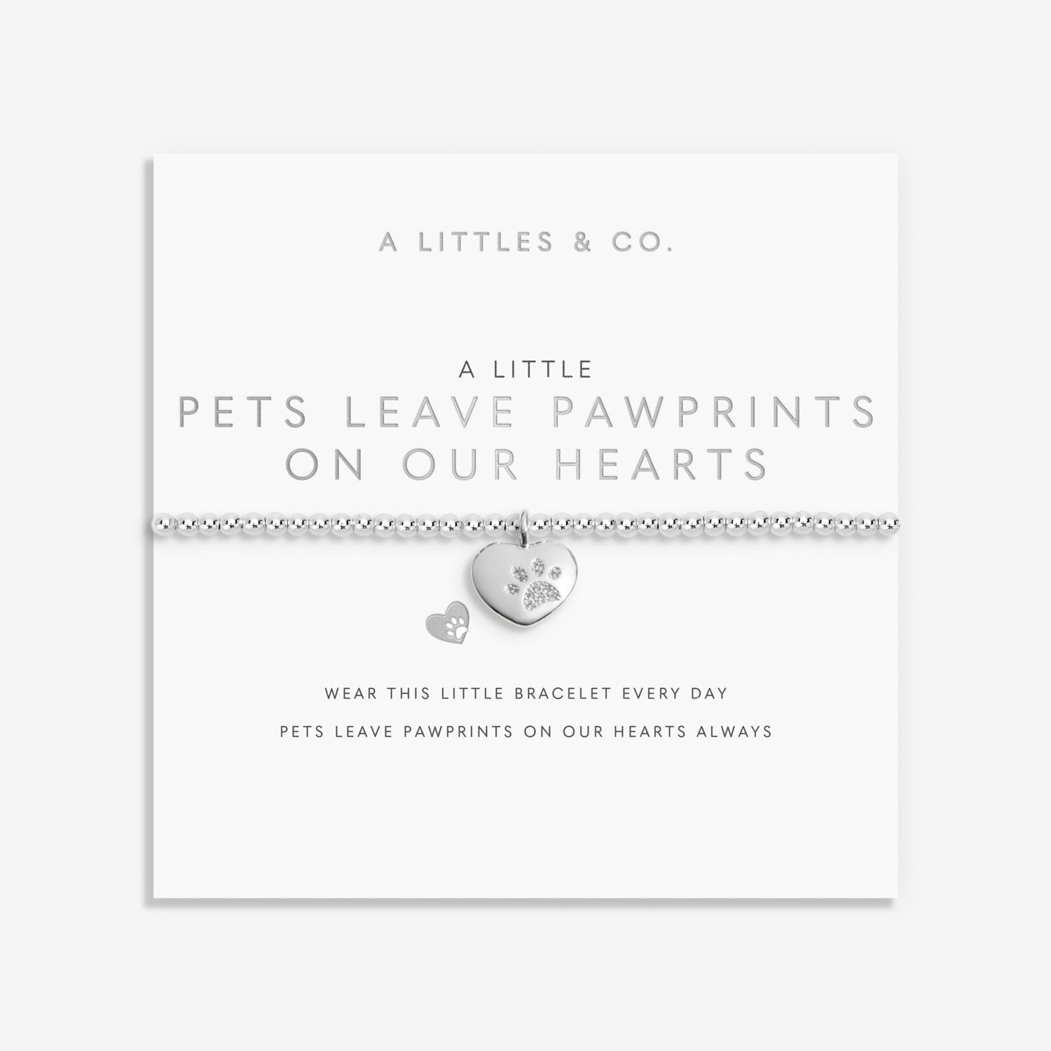 Bracelet with heart-shaped pawprint charm on a white card with text. Available at Be Charmed