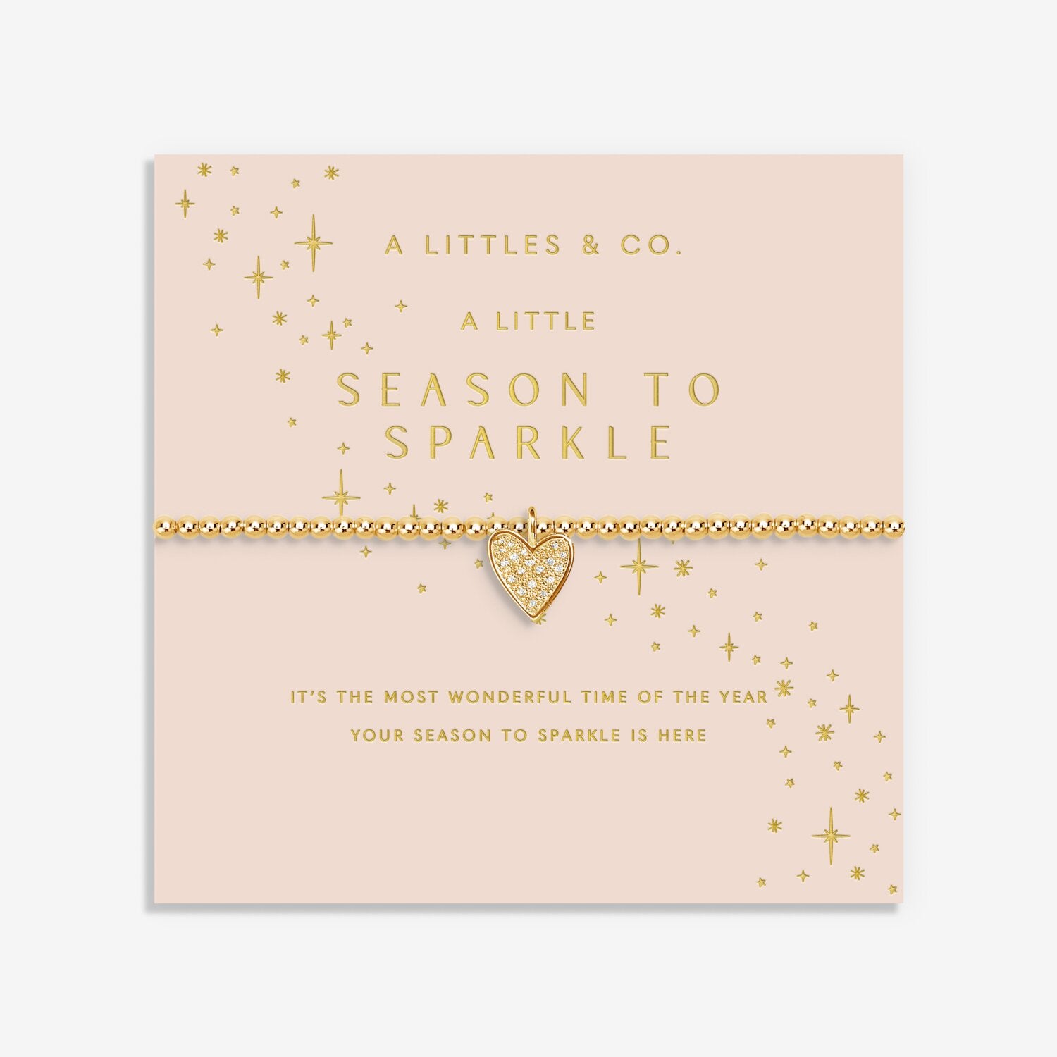 Gold heart bracelet on a pink card with 'A Littles & Co.' branding. Available at Be Charmed