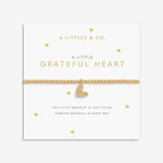 Gold bracelet with heart charm on a white card with 'A Littles & Co.' branding. Available at Be Charmed