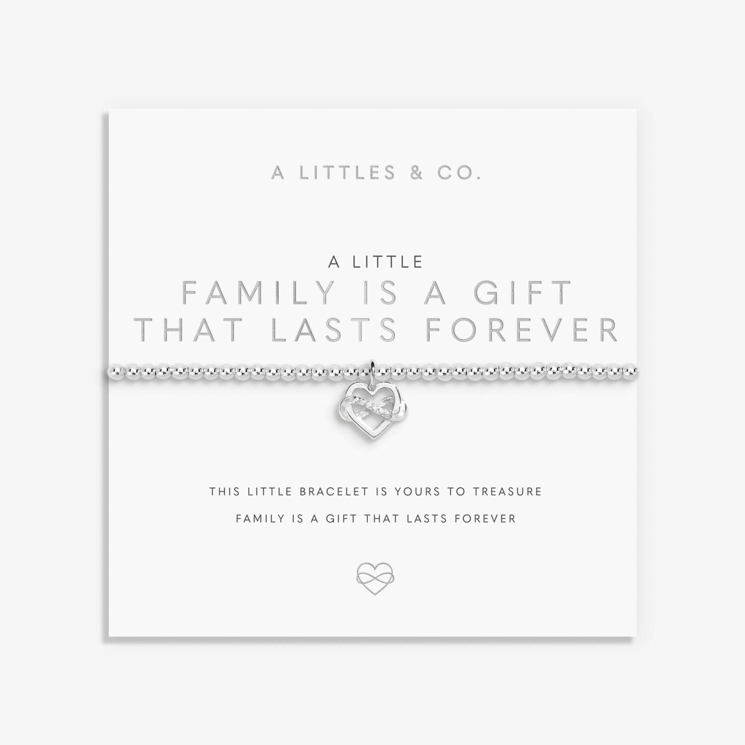 Silver heart-shaped bracelet on a white card with text about family and forever, brand 'A Littles & Co.' visible. Available at Be Charmed