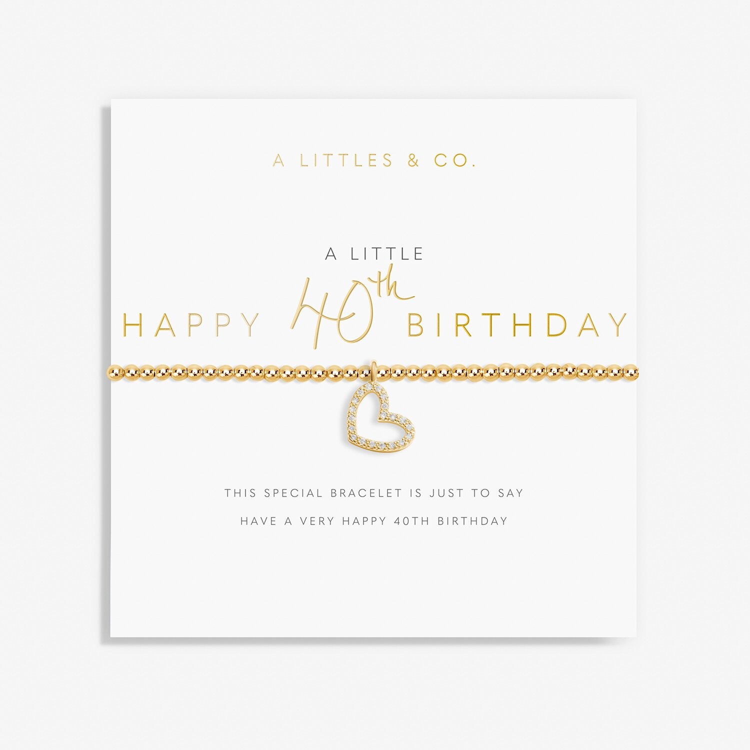 Gold heart bracelet on a white card with 'A Littles & Co' text. Available at Be Charmed