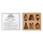Open box of Creative Brands Birthday cookie cutter set in a magnetic book-style box with 6 stainless steel shapes (cake, balloon, candle, present, party hat, heart) and a lemon sugar cookie recipe inside lid—Available at Be Charmed