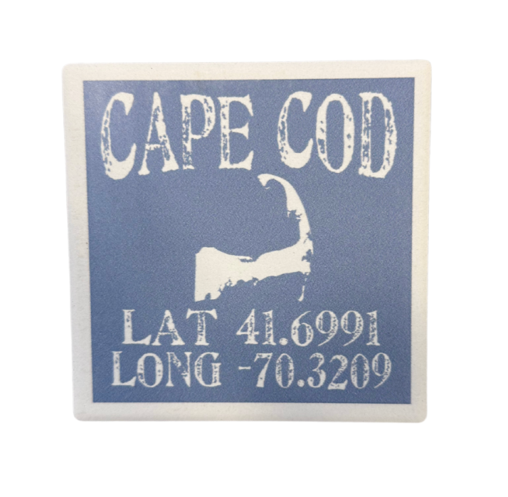 A square tile coaster with cork backing, featuring the text 'CAPE COD' along with latitude and longitude coordinates. Available at Be Charmed