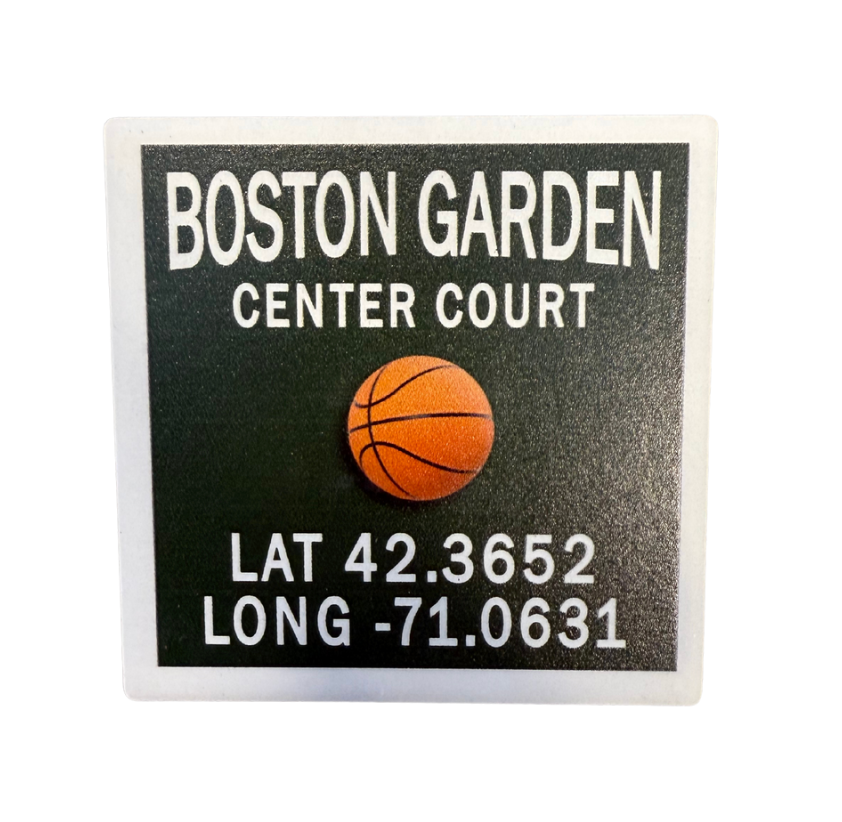 A square coaster with rounded edges featuring an image of a basketball and the text 'Boston Garden Center Court' along with coordinates. Available at Be Charmed