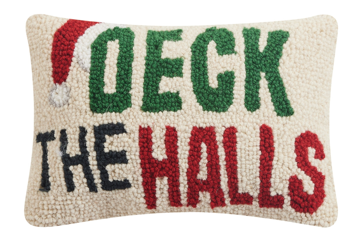 Decorative pillow with 'Deck the Halls' text in green, red, and black on a white background. Available at Be Charmed