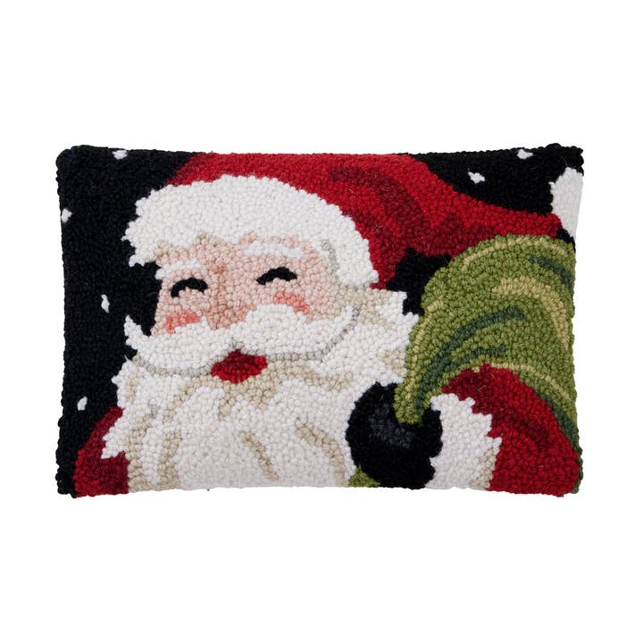 Decorative pillow with a festive design of Santa Claus holding a green bag on a white background. Available at Be Charmed