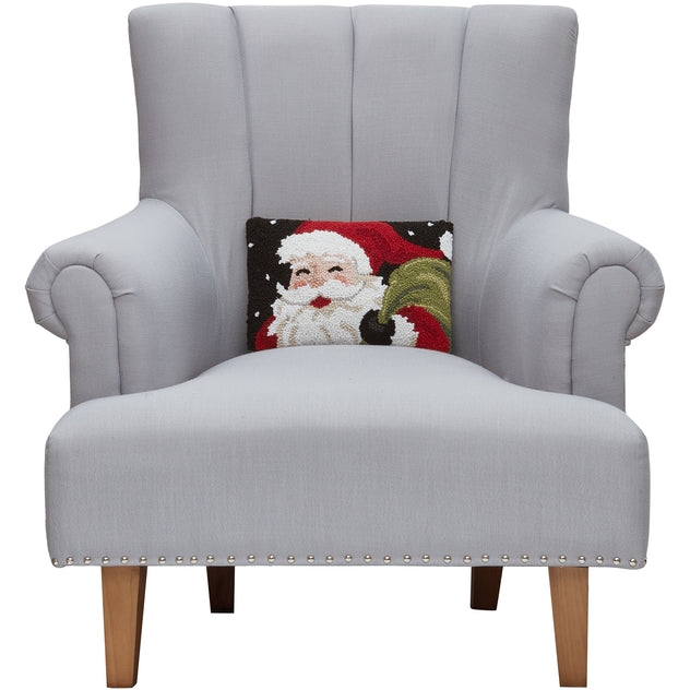 Gray armchair with a Santa Claus pillow on a white background. Available at Be Charmed