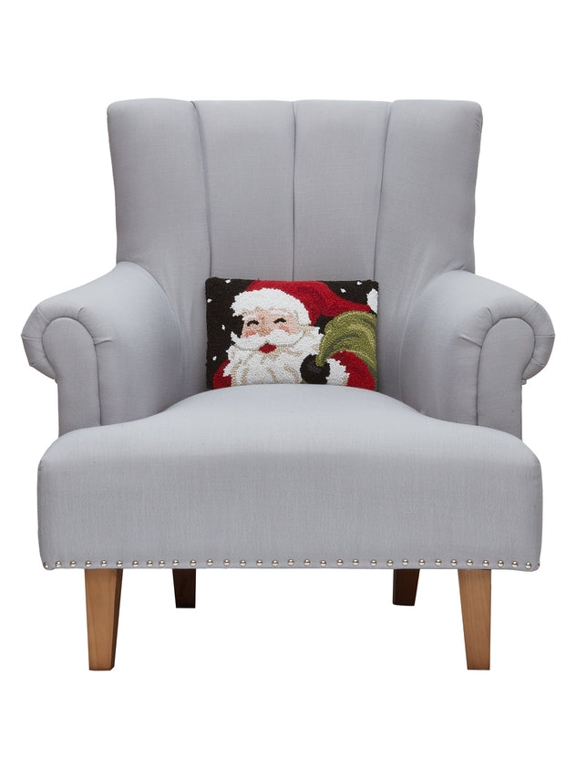 Gray armchair with a Santa Claus pillow on a white background. Available at Be Charmed