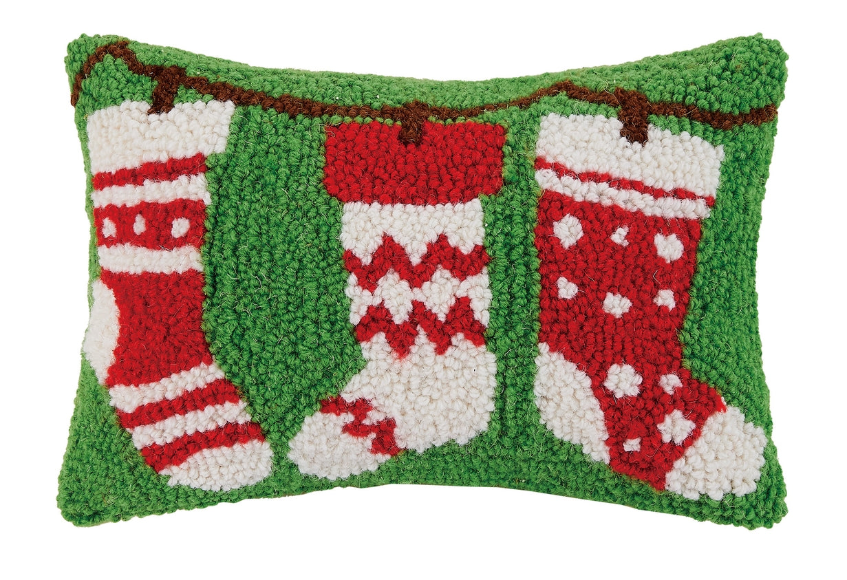 Decorative pillow with red and white stockings on a green background. Available at Be Charmed