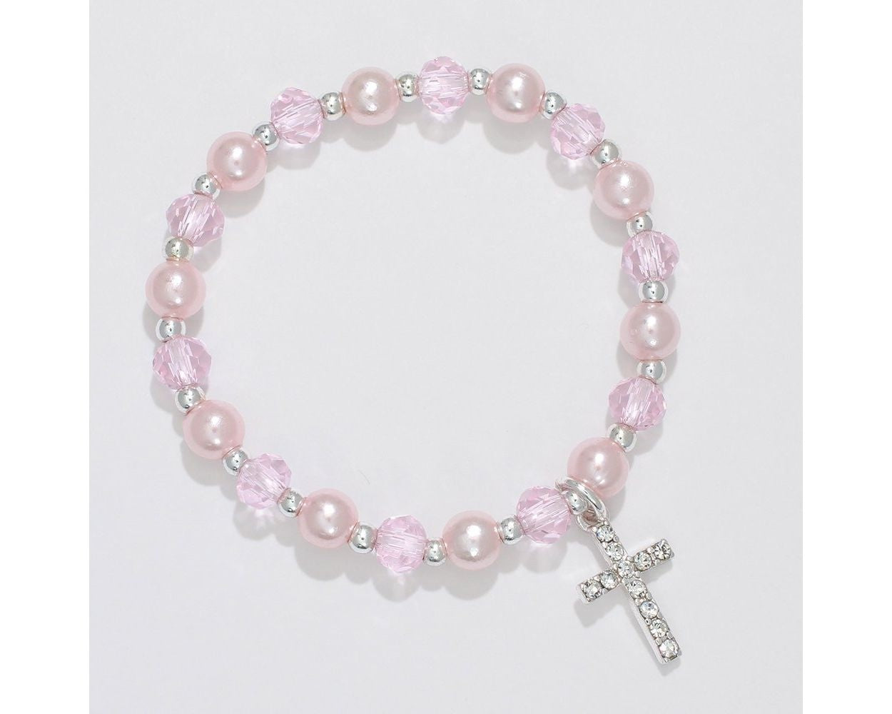 A bracelet with pink pearls and crystals, featuring a crystal cross dangle, gift boxed. Available at Be Charmed