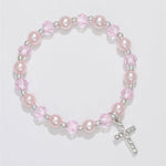 A bracelet with pink pearls and crystals, featuring a crystal cross dangle, gift boxed. Available at Be Charmed