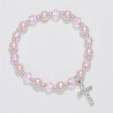 A bracelet with pink pearls and crystals, featuring a crystal cross dangle, gift boxed. Available at Be Charmed