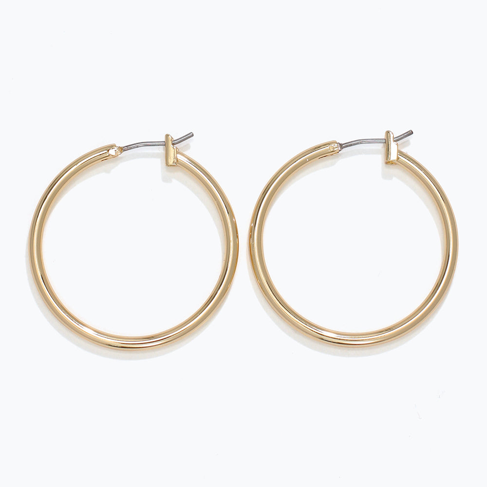 Gold hoop earrings on a white background. Available at Be Charmed