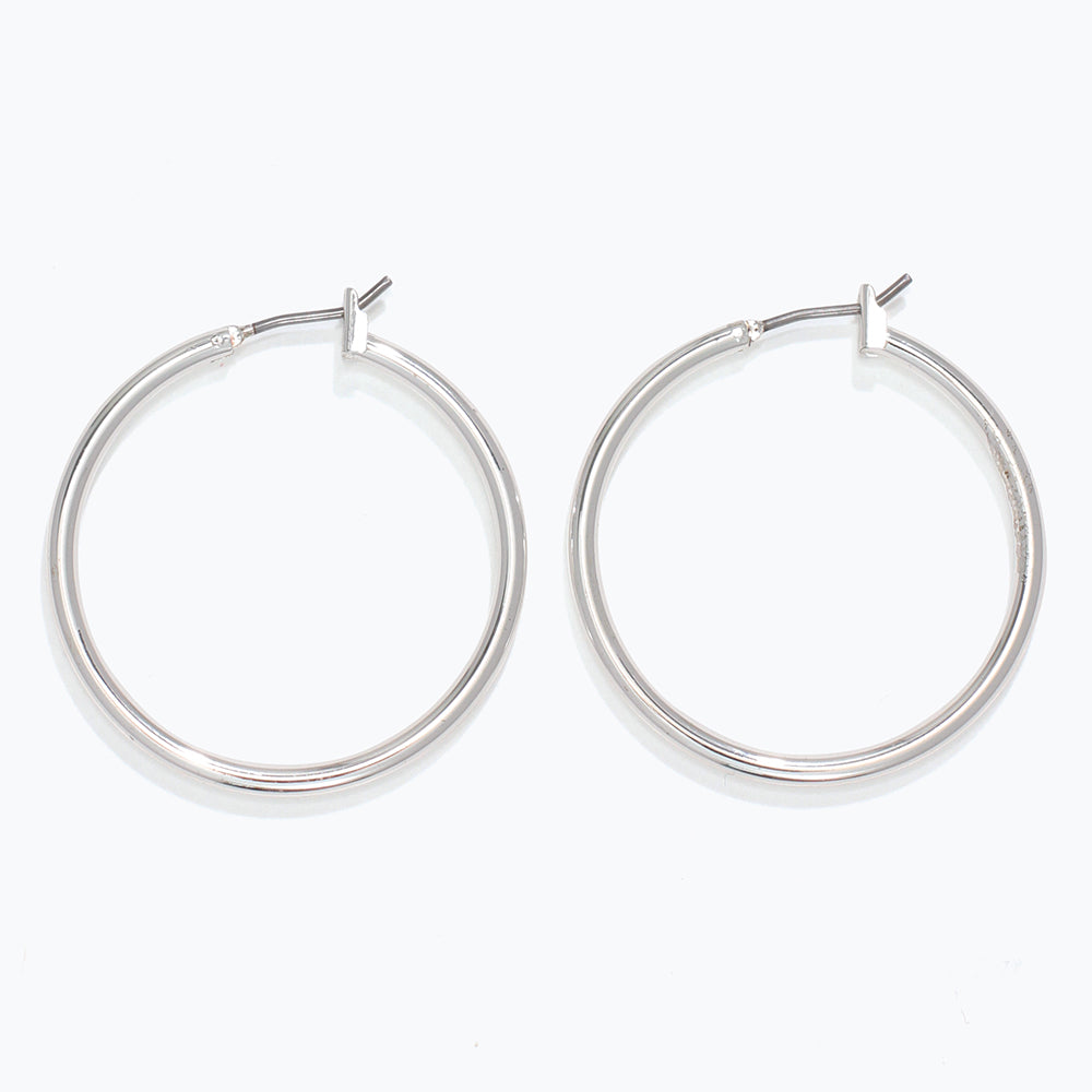 Pair of silver hoop earrings on a white background. Available at Be Charmed