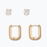 Pair of gold hoop earrings with clear gemstones on a white background.  Available at Be charmed