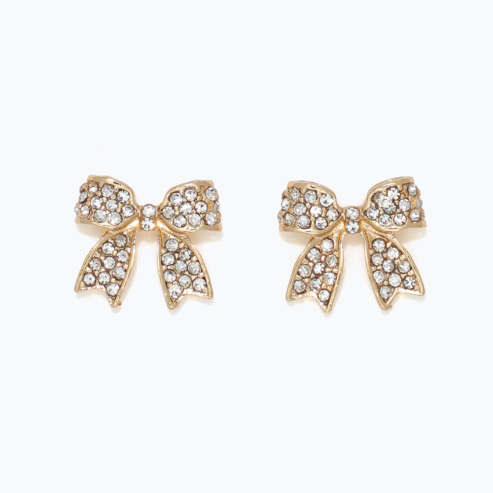 Gold bow-shaped earrings with rhinestones on a white background. Available at Be Charmed