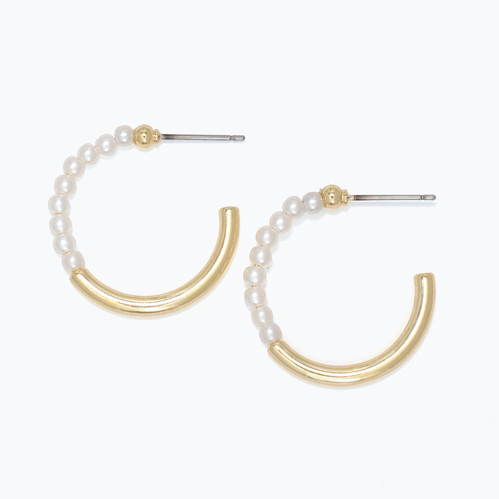 Pair of gold and pearl earrings on a white background. Available at Be Charmed