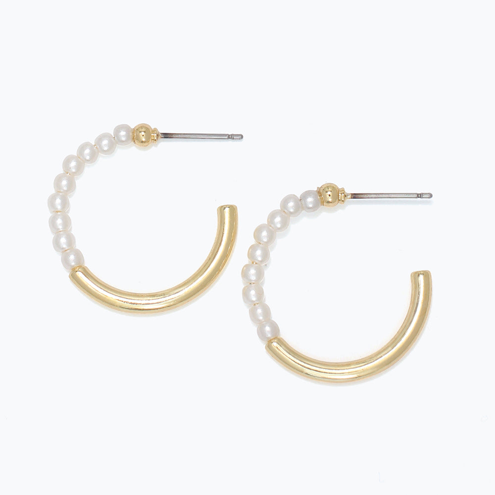 Pair of gold and pearl earrings on a white background. Available at Be Charmed