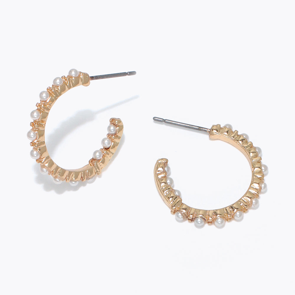 Gold hoop earrings with pearl accents on a white background Available at Be Charmed