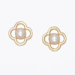 Pair of gold earrings with pearl centers on a white background .Available at Be Charmed