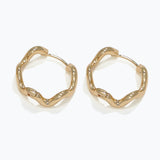 Gold hoop earrings on a white background. Available at Be Charmed