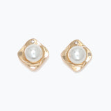Pair of gold earrings with pearl centers on a white background. Available at Be Charmed