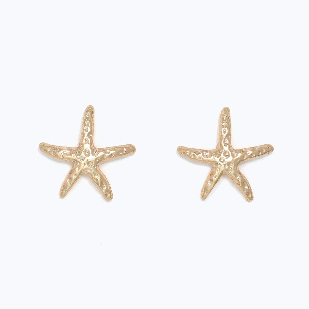 Gold starfish earrings on a white background. Available at Be Charmed