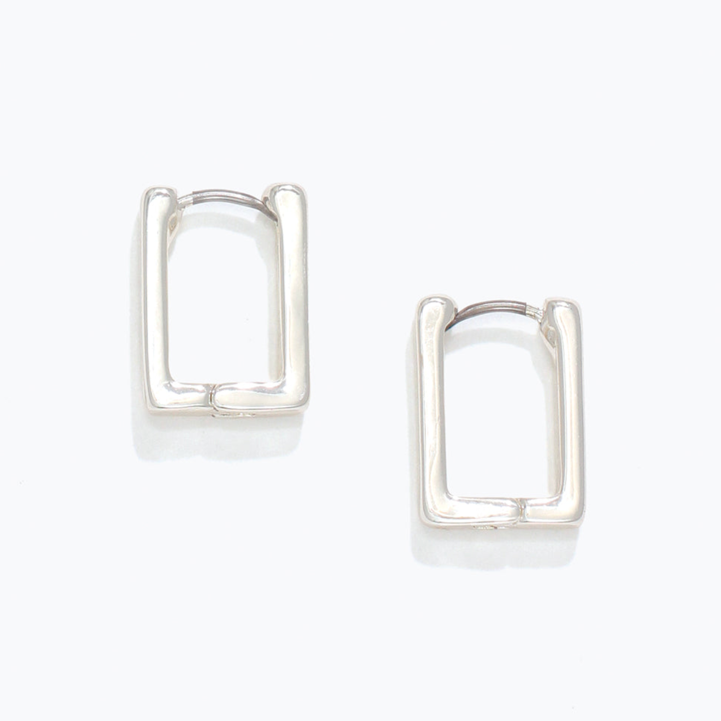 Pair of silver hoop earrings on a white background. Available at Be Charmed