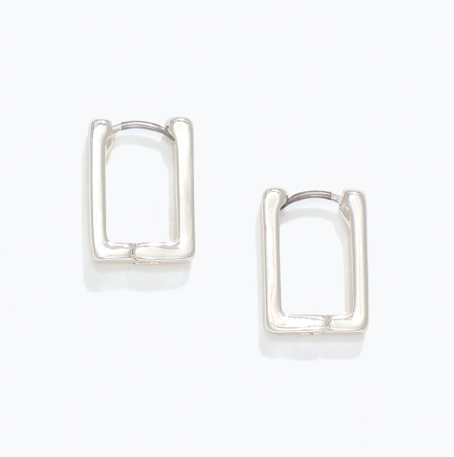 Pair of silver hoop earrings on a white background. Available at Be Charmed