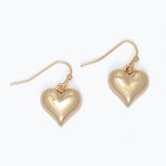 Gold heart-shaped earrings on a white background. Available at Be Charmed