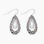 Silver teardrop earrings with intricate designs on a white background. Available at Be charmed