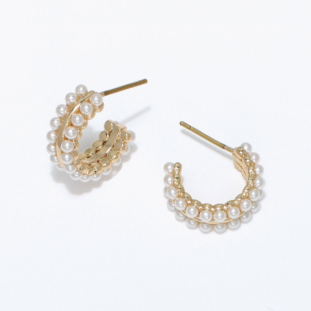 Gold hoop earrings with pearl accents on a white background. Available at Be Charmed