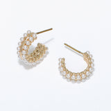 Gold hoop earrings with pearl accents on a white background. Available at Be Charmed
