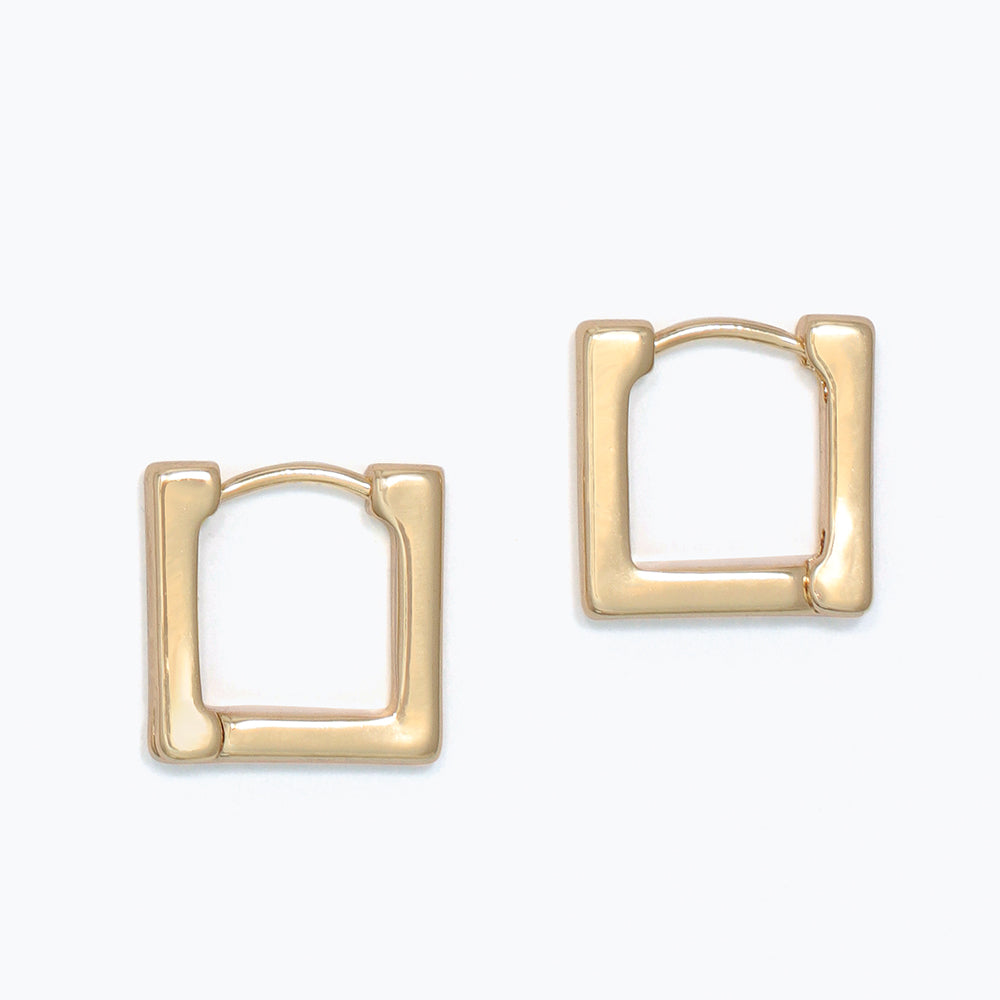 Gold hoop earrings on a white background. Available at Be Charmed