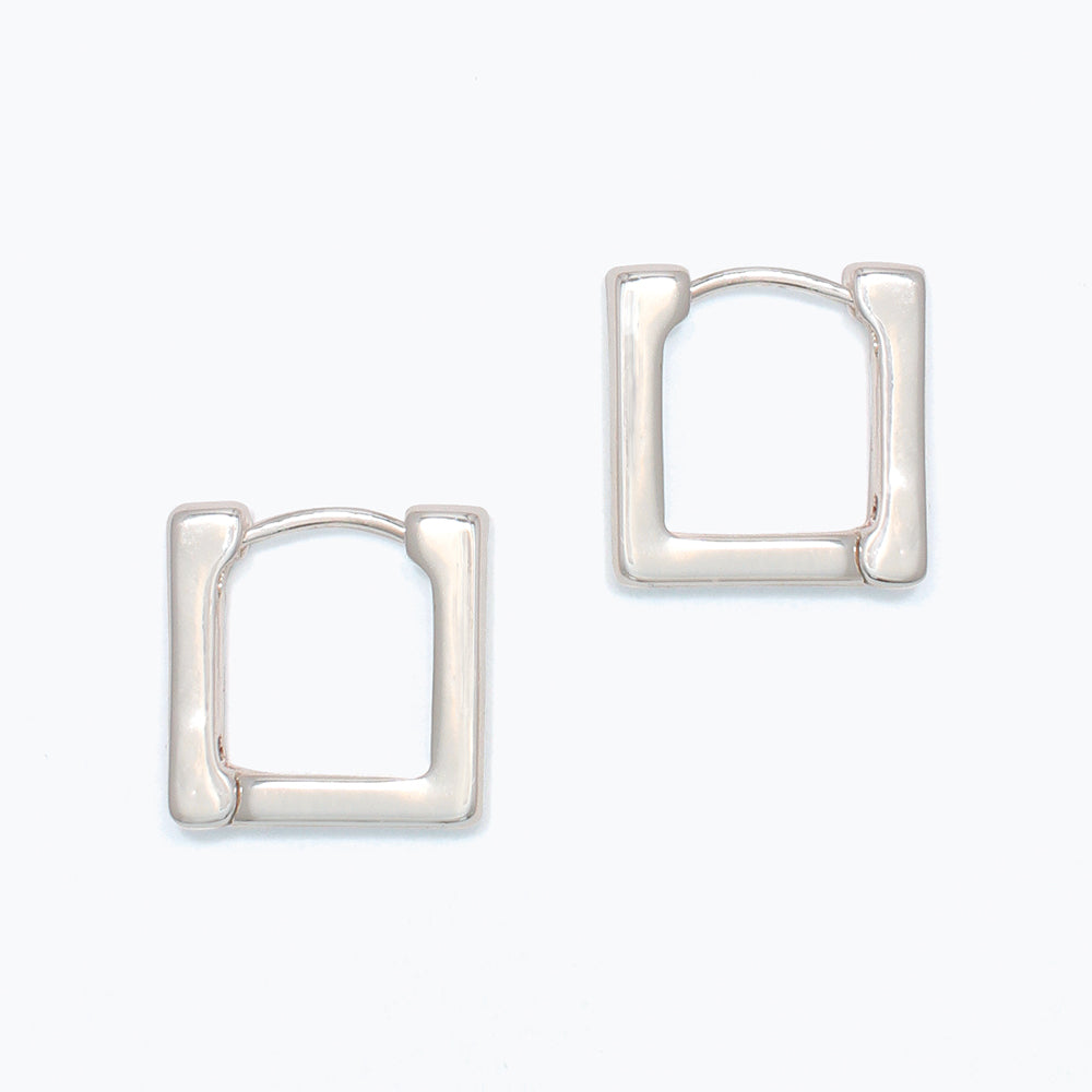 Pair of silver hoop earrings on a white background. Available at Be Charmed