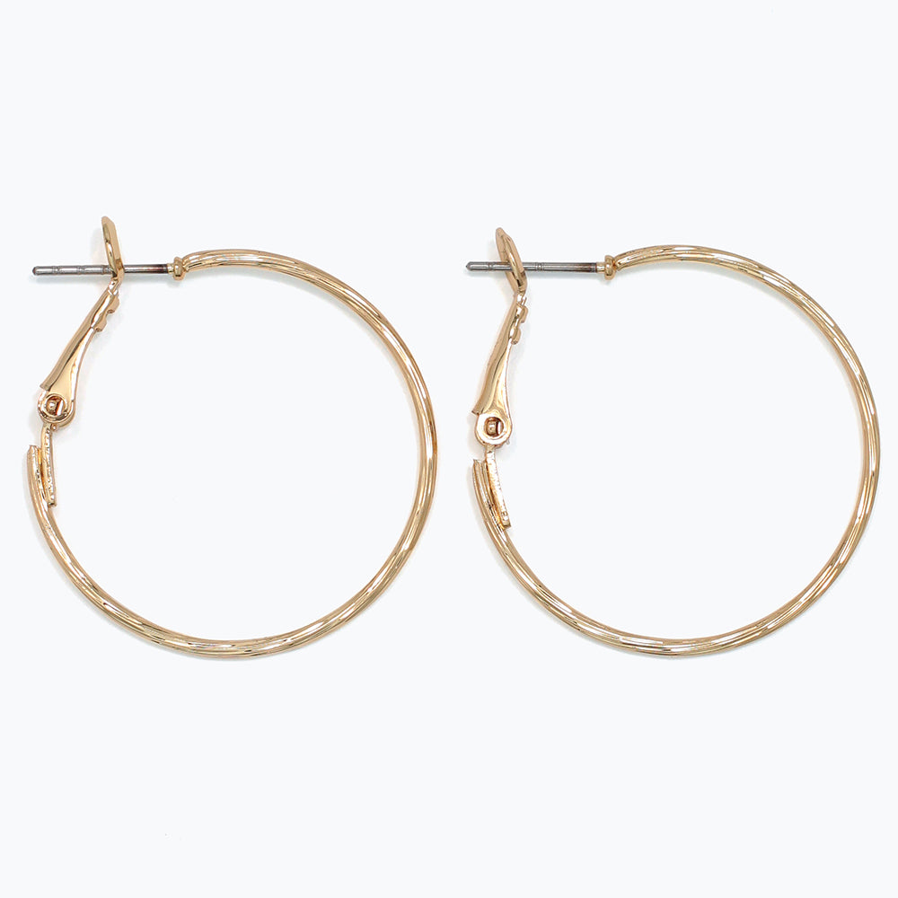 Gold hoop earrings on a white background. Available at Be Charmed