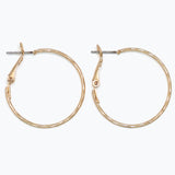 Gold hoop earrings on a white background. Available at Be Charmed
