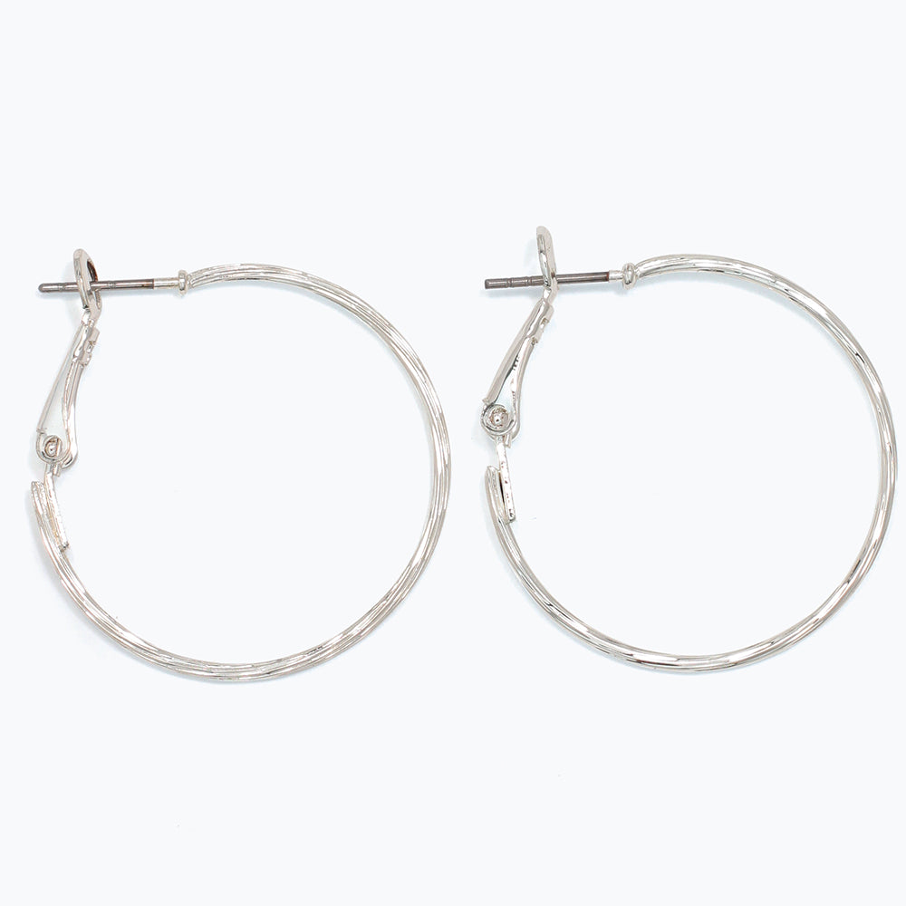 Silver hoop earrings on a white background. Available at Be Charmed