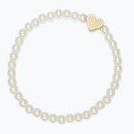 Kids pearl bracelet with a gold heart charm on a white background. Available at Be Charmed. 