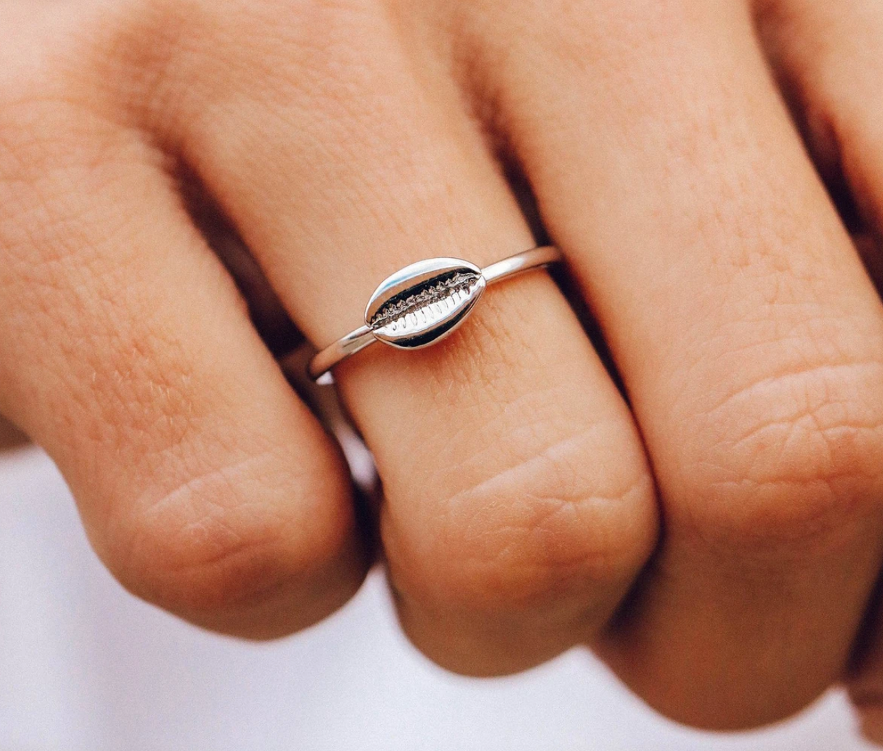 Person wearing a Pura Vida Cowrie Shell Ring available at Be Charmed