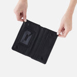 Black HOBO wallet with card slots held open by hands on a white background