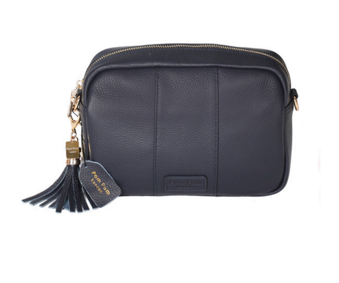 Navy Pom Pom London City Bag – handcrafted leather crossbody with interchangeable straps and London-inspired design. Available at Be Charmed.