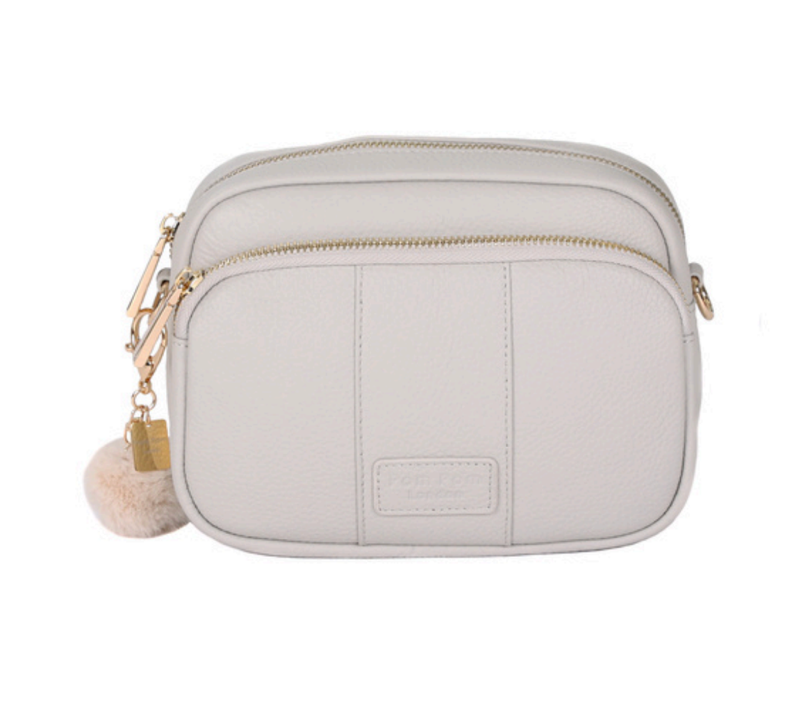 Oatmeal Pom Pom London Original Bag – classic handcrafted leather crossbody with adjustable and interchangeable straps. Available at Be Charmed.