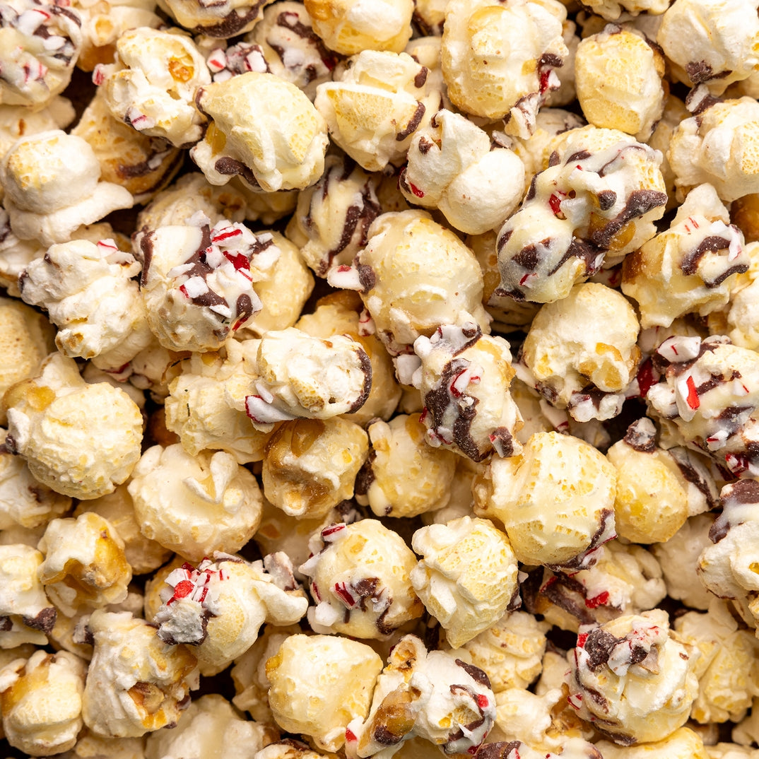 Close-up of poppy peppermint bark popcorn with chocolate chips and candy cane bits. Available at Be Charmed. 