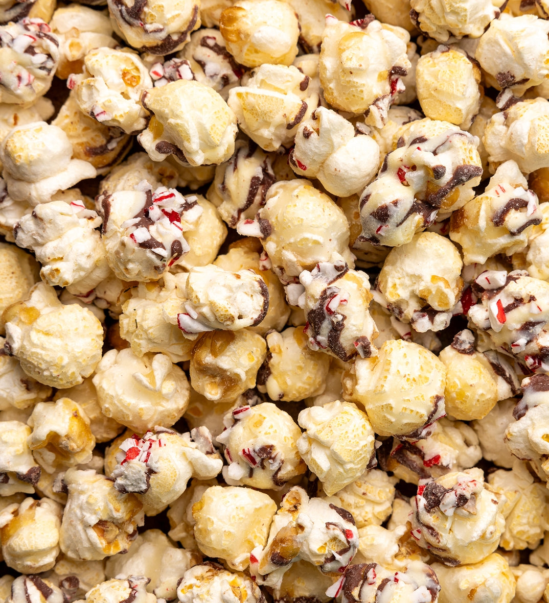 Close-up of poppy peppermint bark popcorn with chocolate chips and candy cane bits. Available at Be Charmed. 
