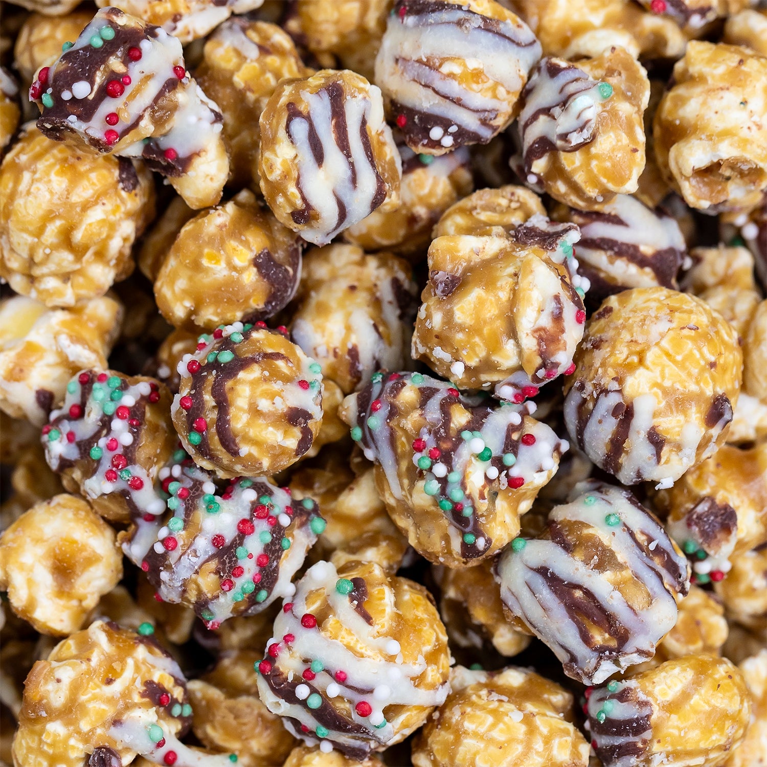 Close-up of christmas caramel popcorn with chocolate drizzle and sprinkles. Available at Be Charmed. 